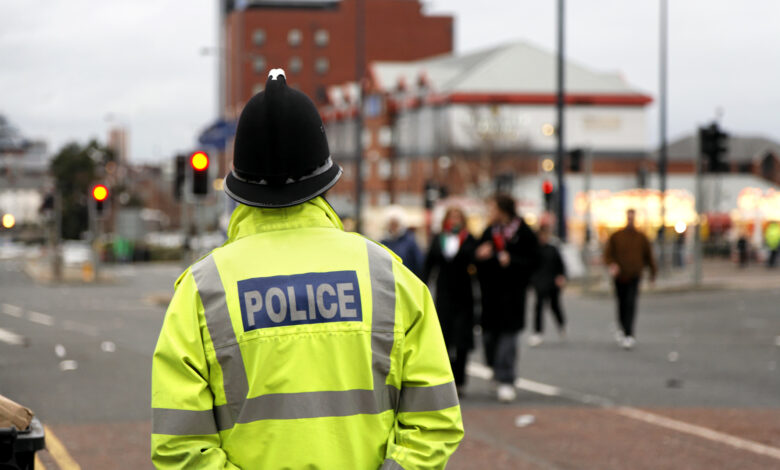 British Policeman Wearing Tradtional Helmet Observes People