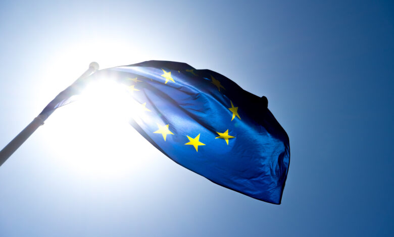 Series of images of the EU flag flying in the wind, backlight and blue sky